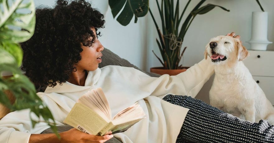 Women looking at her dog with book in her hand while learning about affordable pet insurance