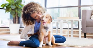 Women smiling and hugging her new mixed breed puppy