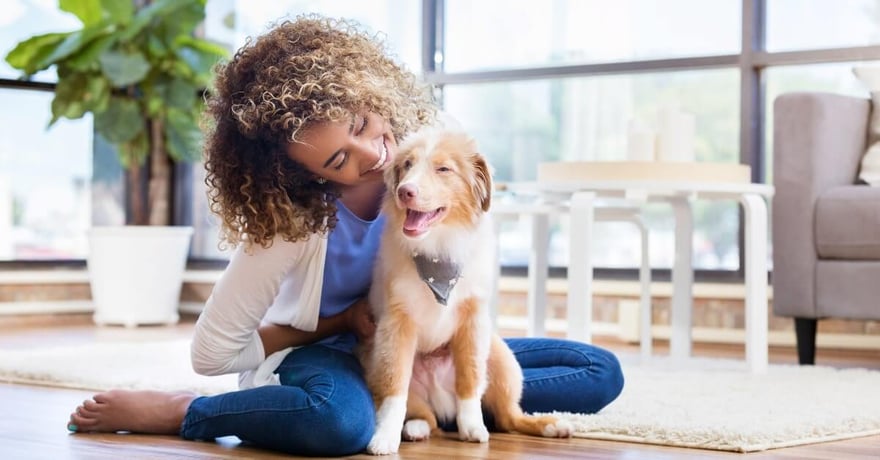 Women smiling and hugging her new mixed breed puppy