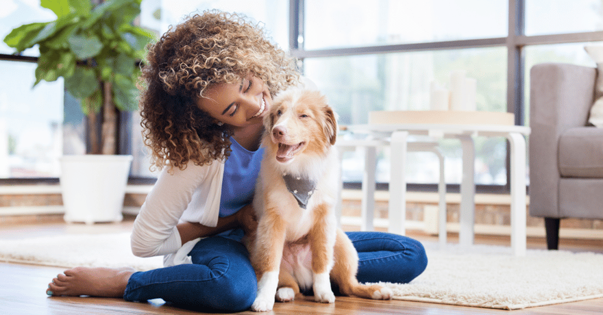 Women smiling and hugging her new mixed breed puppy